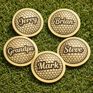 Five gold commemorative coins with engraved names on a grass background