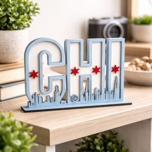 Decorative sign with 'CHI' and city skyline on a wooden surface with plants and books in the background.