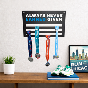 Medal holder with medals on a wall above a desk with sneakers and a plant.