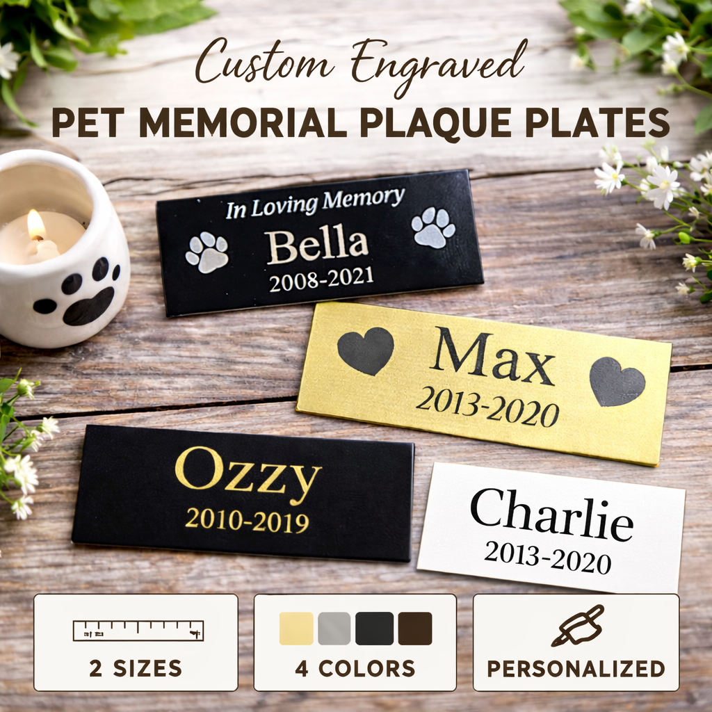 Custom engraved pet memorial plaque plates on a wooden surface with candles and flowers.