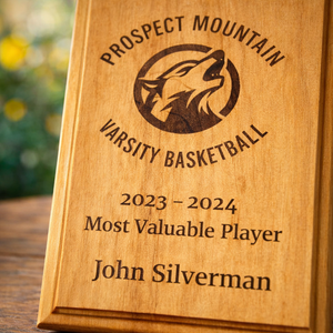 Wooden plaque with engraved text for Prospect Mountain Varsity Basketball Most Valuable Player award.