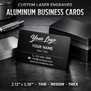 Black custom laser engraved aluminum business card with branding details on a dark surface.