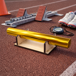 Wooden relay baton stand holding a gold track baton on a running track with starting blocks and stopwatch in the background