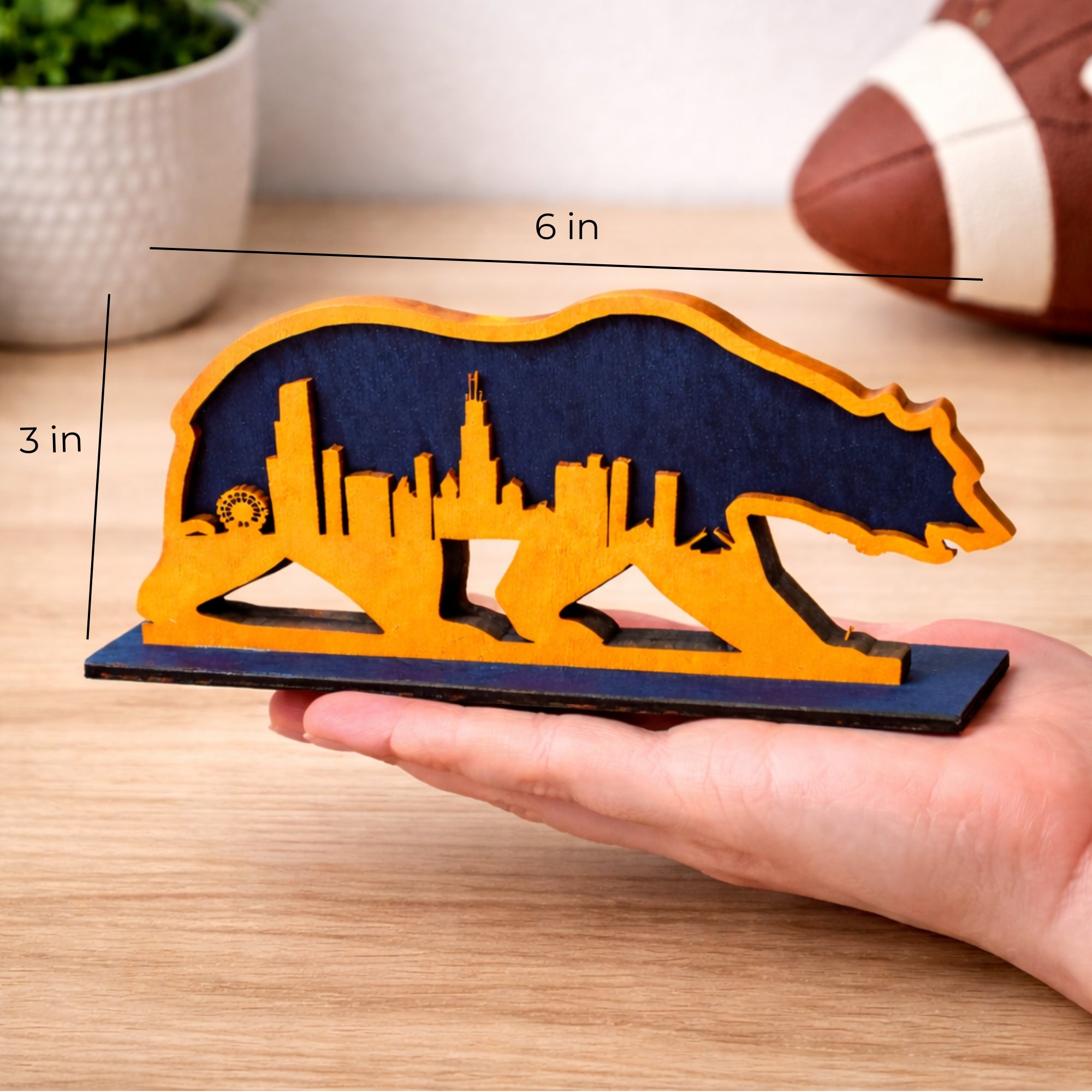 Hand holding a 3 by 6 inch Chicago skyline bear mini wood shelf sign to show size
