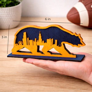 Hand holding a 3 by 6 inch Chicago skyline bear mini wood shelf sign to show size
