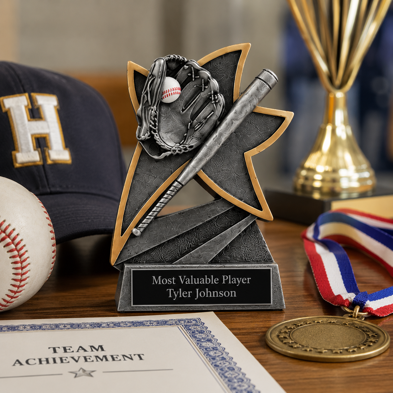 Personalized baseball trophy with engraved name plate displayed on a wooden table alongside a baseball medal, championship trophy, baseball cap, and team achievement certificate.