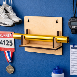 Wooden wall mount with gold bar, running bib, medal, and stopwatch on a blue wall.